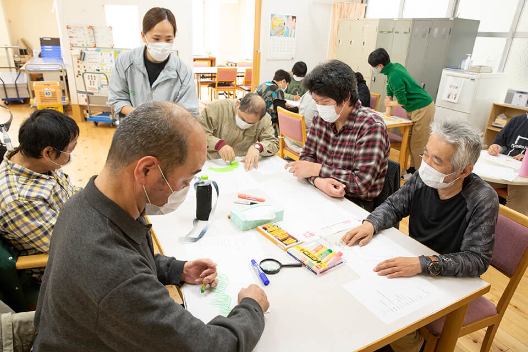 障害者支援施設で映像の題字や挿絵を描く様子