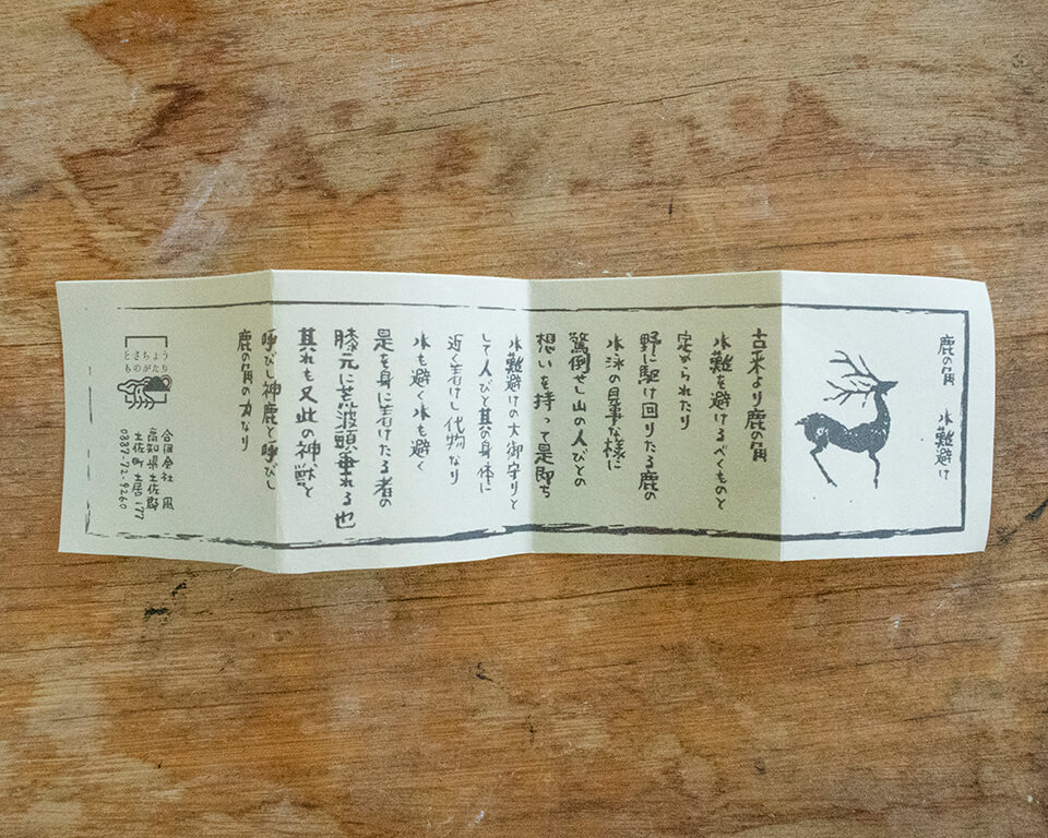 折りたたまれた土佐和紙の御守り紙。カプセルごとに一枚ずつ同封している。